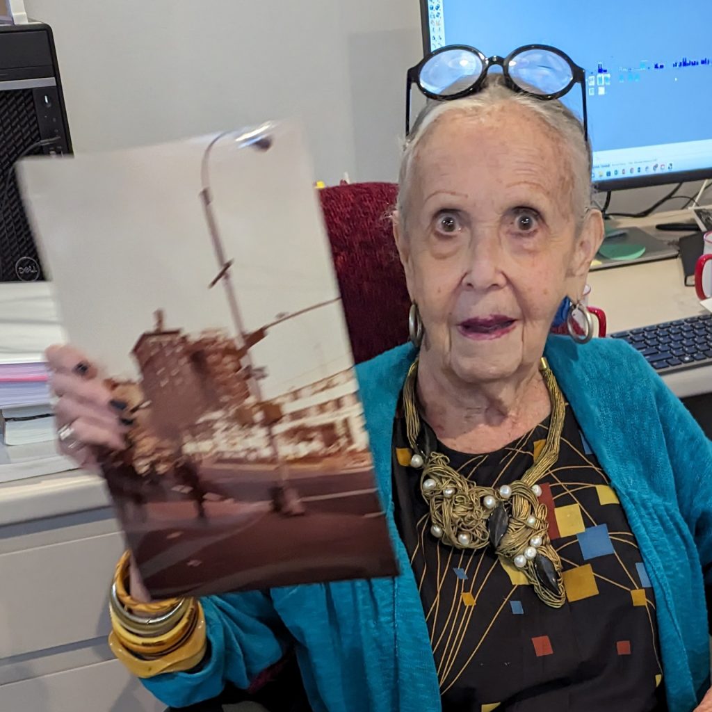 Color photo of JILL Gill holding a vintage photo of the Upper West Side